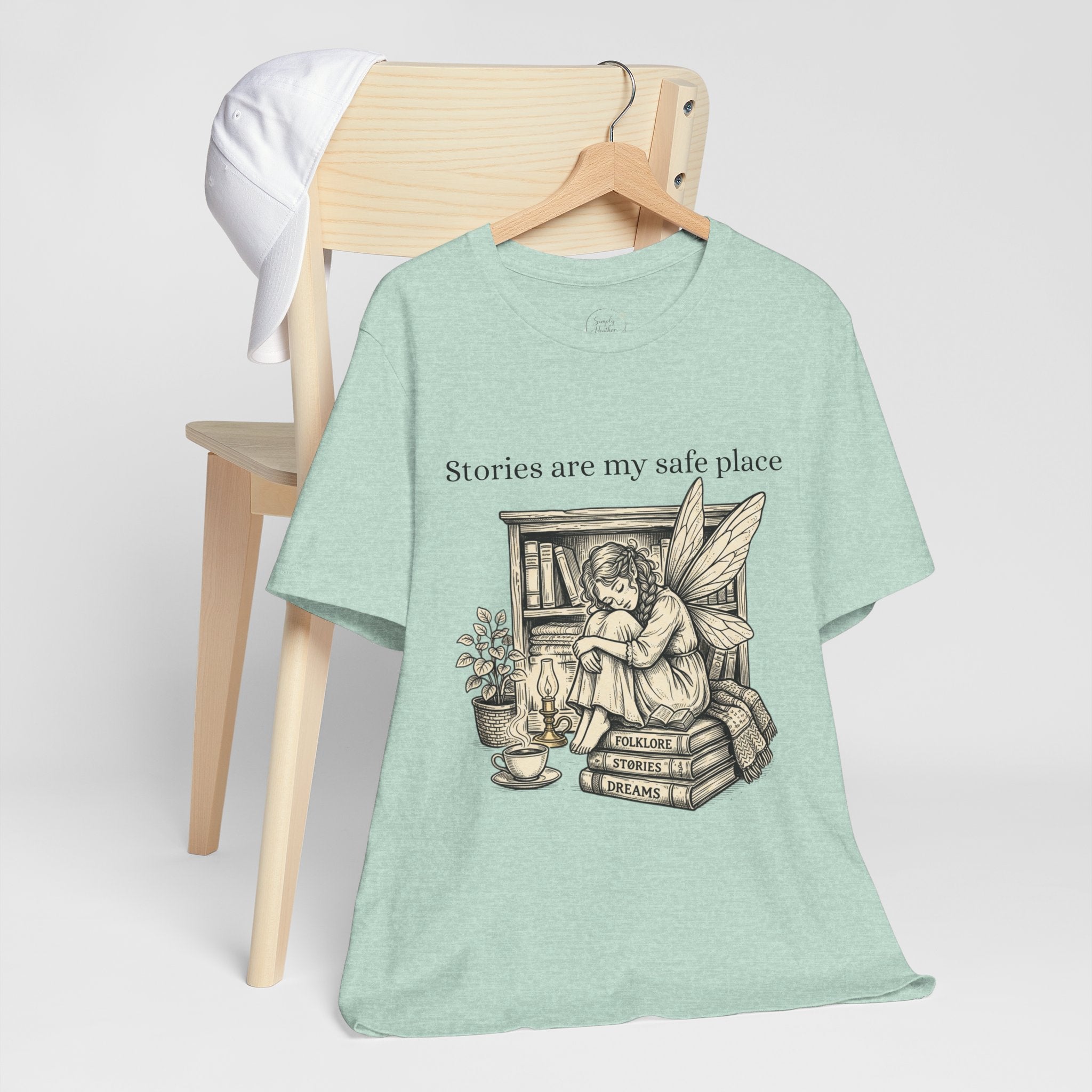 Fairy reading booklover T-shirt with "Stories Are My Safe Place" slogan, casual graphic tee for book enthusiasts and fairy fans.