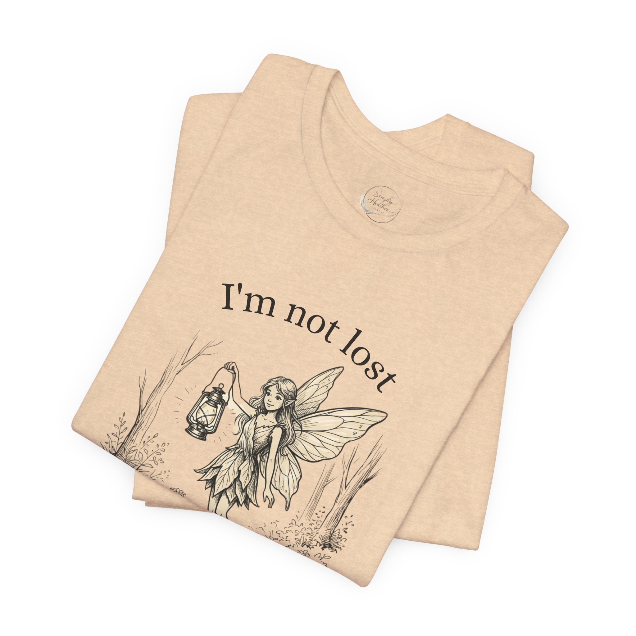 Pink graphic T-shirt by Printify featuring the phrase "I’m Not Lost, I’m Exploring" with fairy and exploration-themed design.