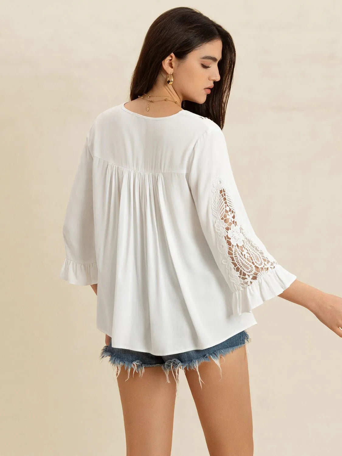 Back view of white lace flounce sleeve V-neck blouse by Trendsi, featuring delicate lace details and a feminine silhouette.