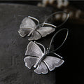 Sterling silver Moonshadow Moth earrings with French hooks, showcasing detailed moth design and elegant craftsmanship.