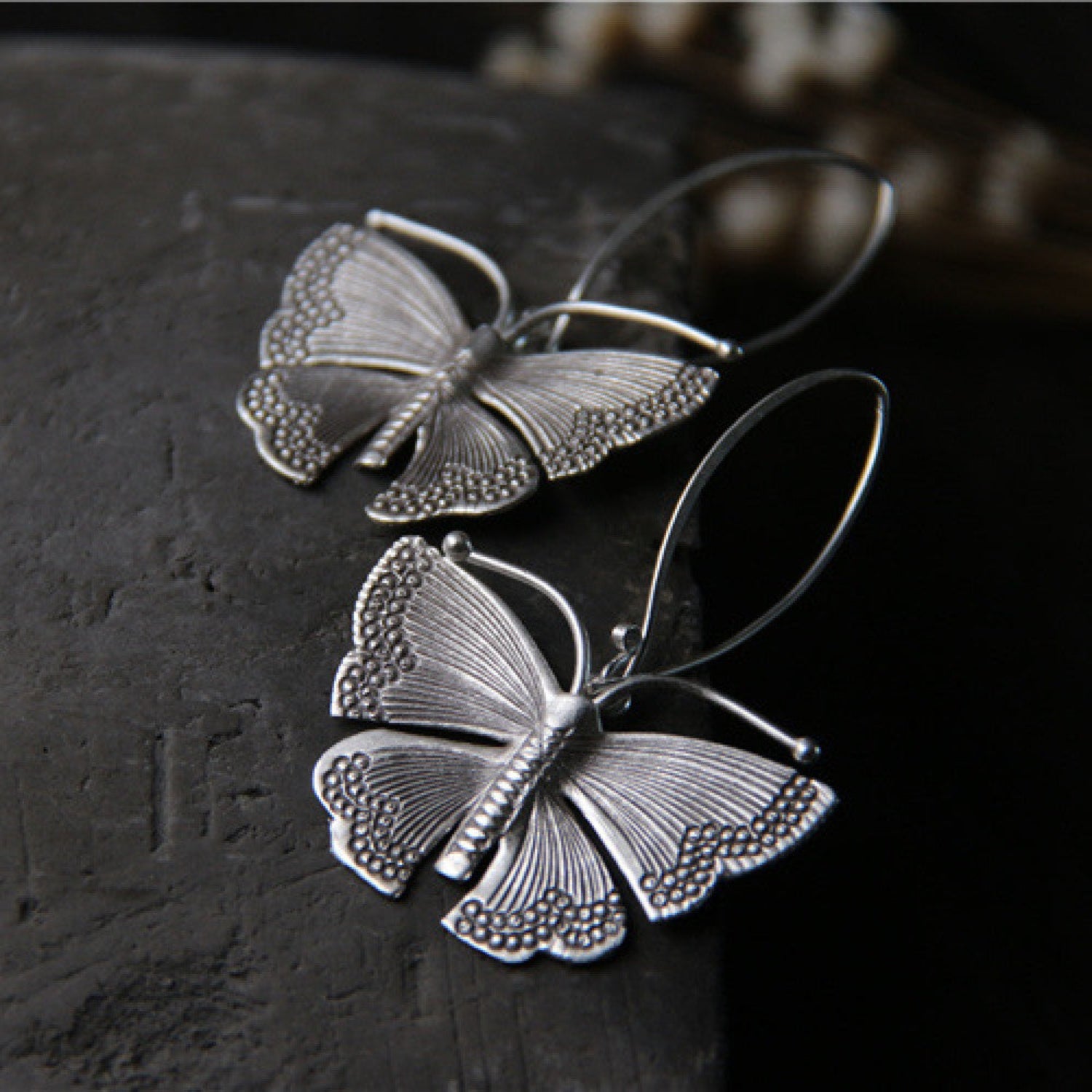 Sterling silver Moonshadow Moth earrings with French hooks, showcasing detailed moth design and elegant craftsmanship.