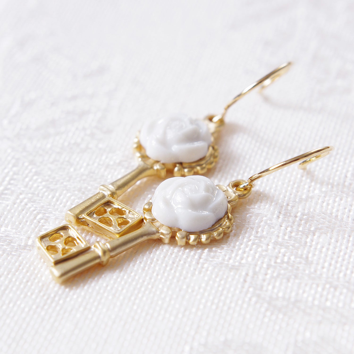 Golden porcelain Camellia Key earrings from POPORCELAIN's Rosehaven Secret Garden Collection, featuring delicate floral and key designs.