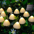 Lumenwood Glowcap solar mushroom pathway lights illuminating a garden walkway with colorful LED caps.