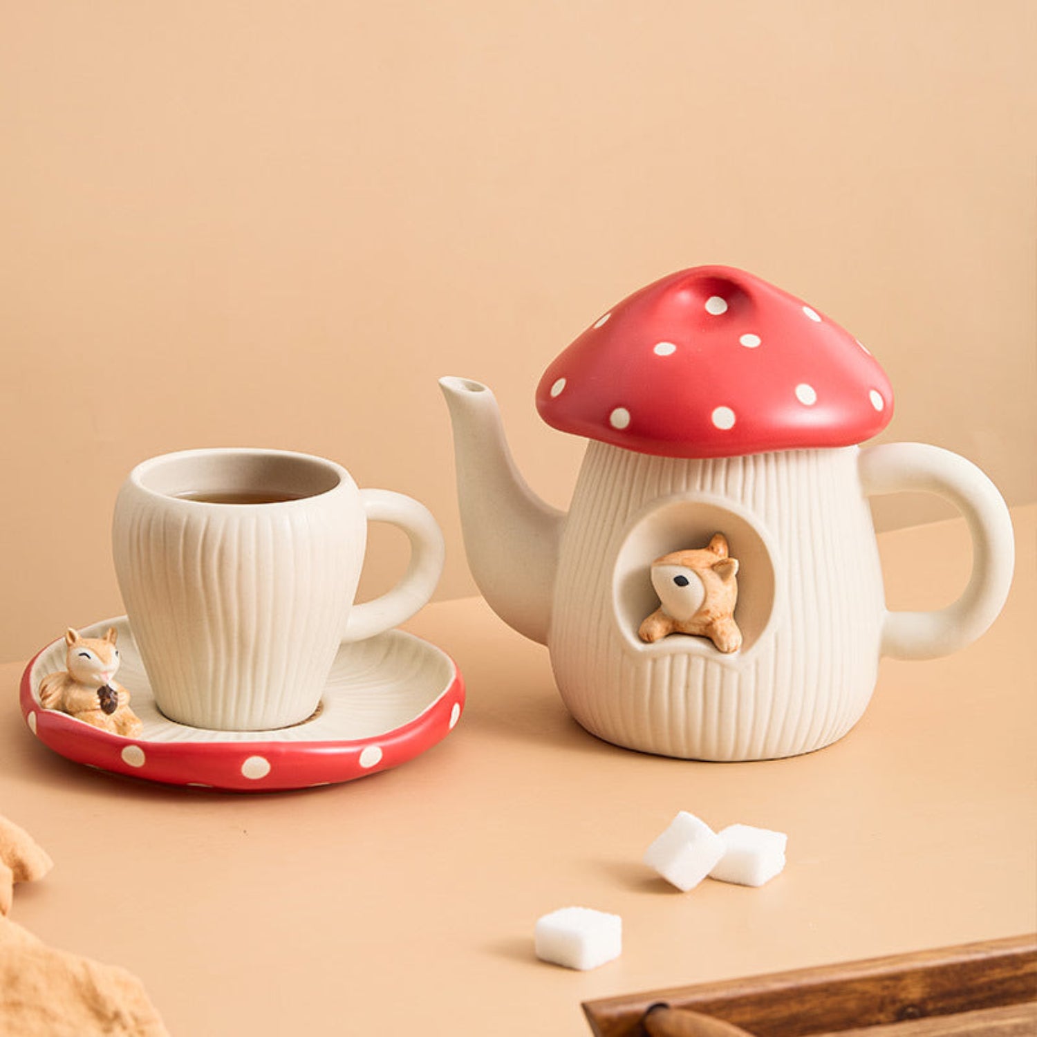 Woodland mushroom ceramic tea set with a toadstool-shaped teapot and matching cup, ideal for charming tea service.