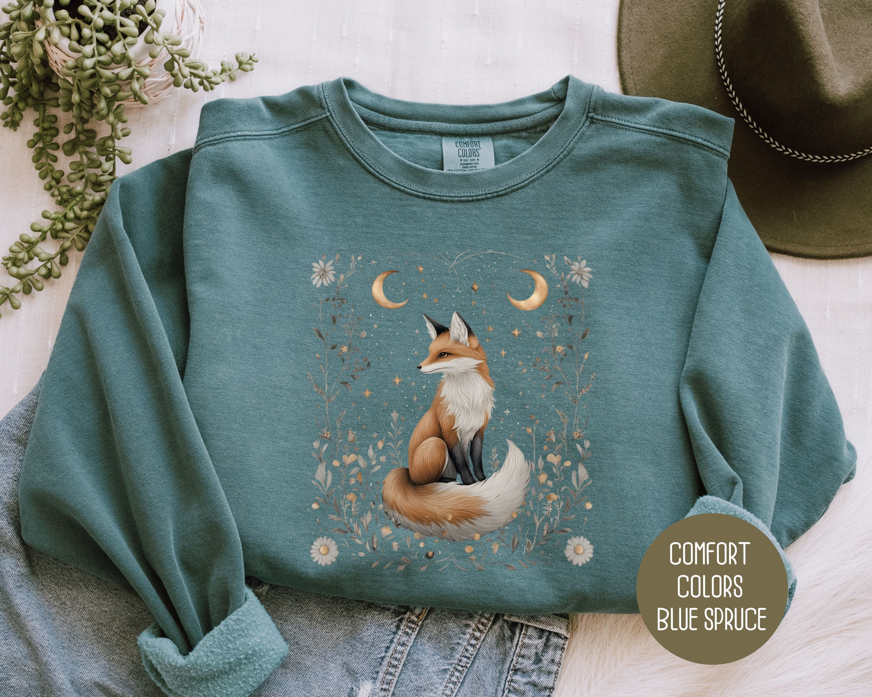 Blue sweatshirt featuring a celestial fox design from the Starlit Hollow collection by CreativeSpecialTs, front view.