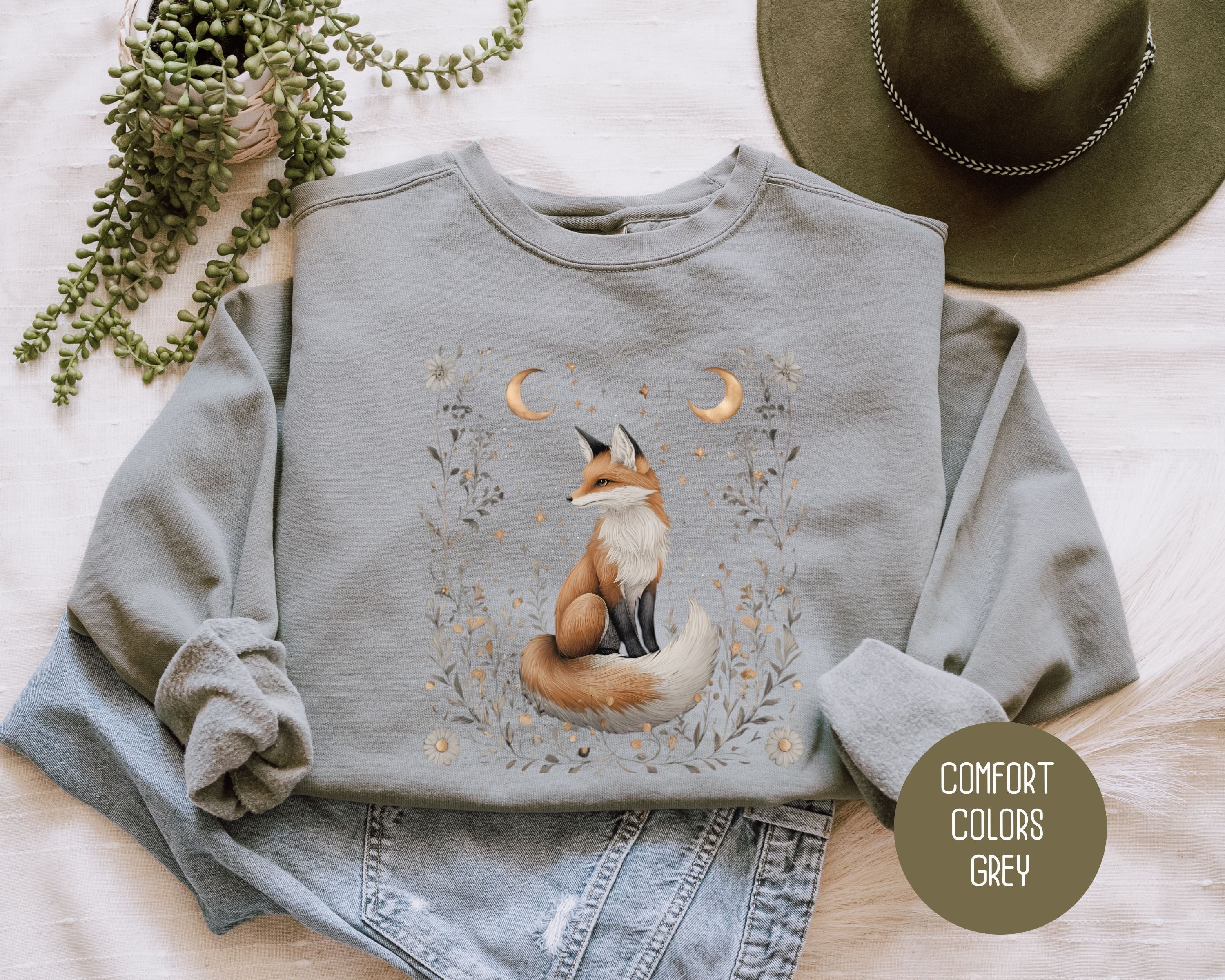Grey Comfort Colors sweatshirt featuring a starlit hollow celestial fox graphic on the front.