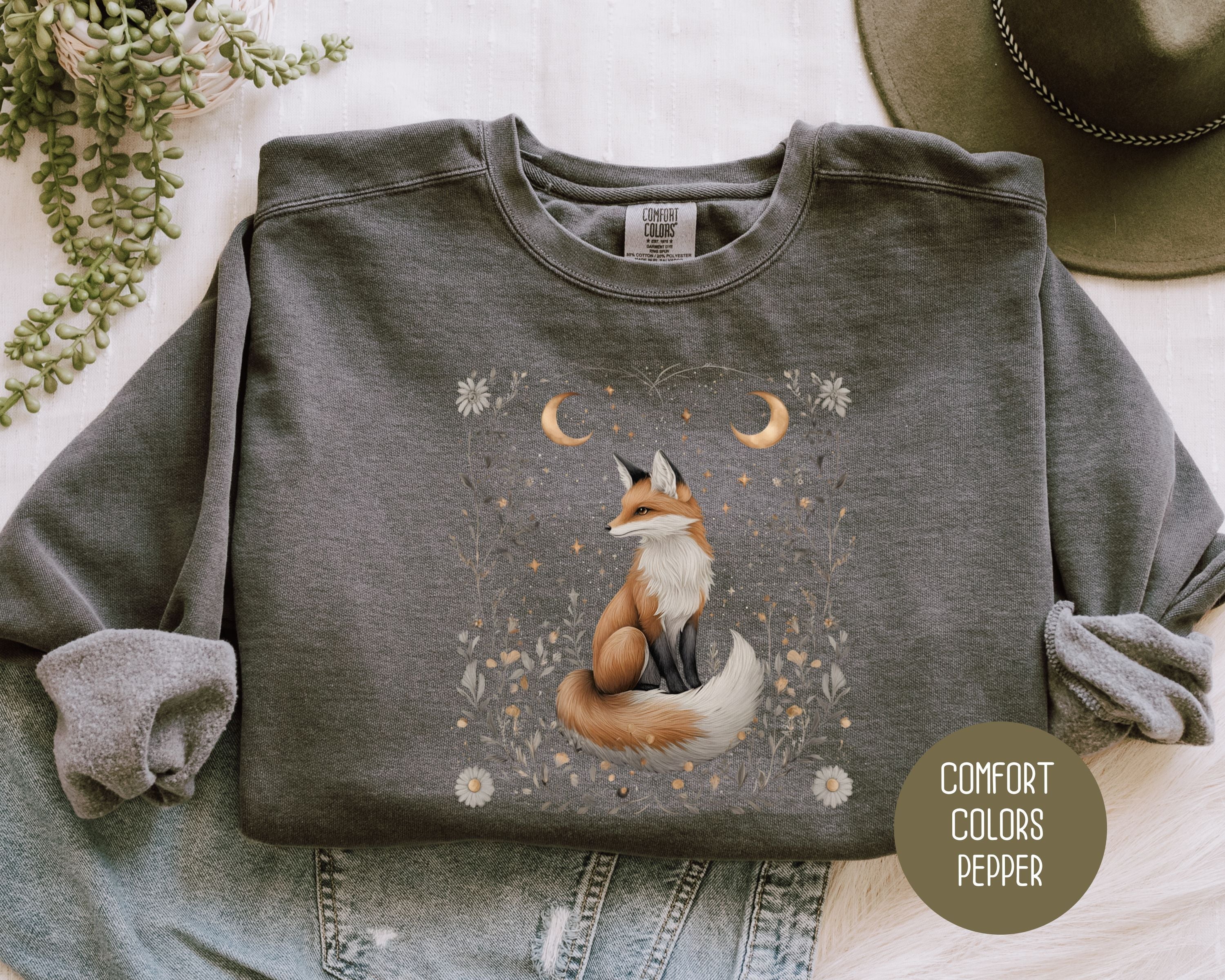 Cream-colored Comfort Colors sweatshirt with a starlit hollow celestial fox design on the front, by CreativeSpecialTs.