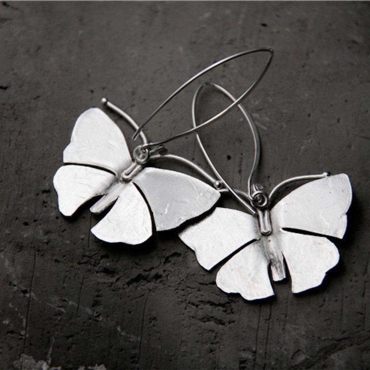 Sterling silver Moonshadow Moth earrings with French hook design, showcasing intricate moth details from the back view.