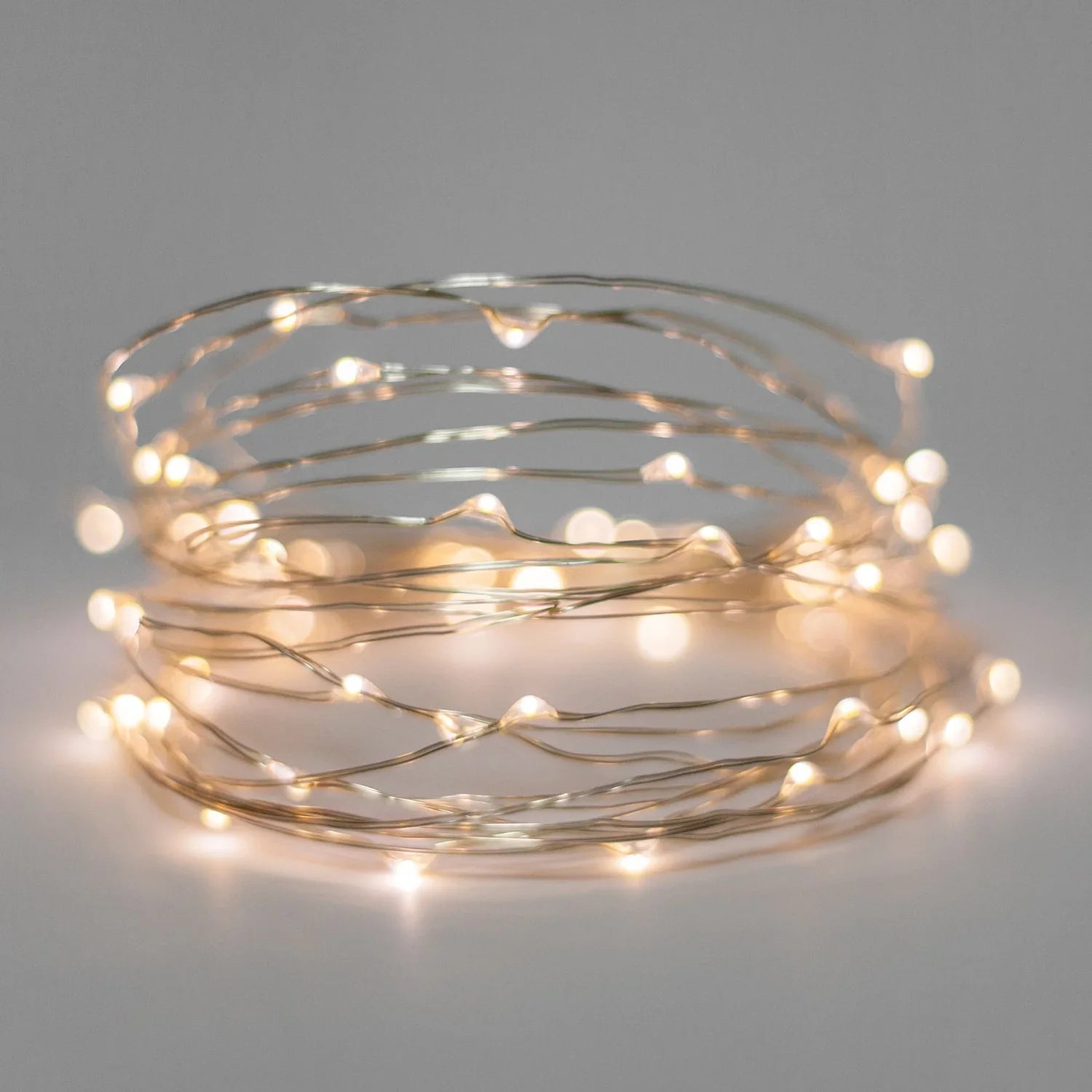 20 LED silver copper fairy lights from Perfect Holiday emitting a soft golden glow, battery operated for versatile indoor use.
