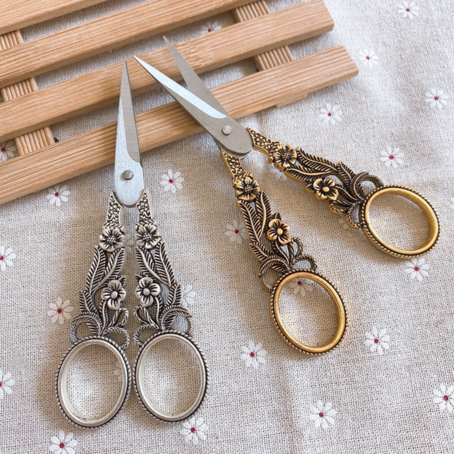 Vintage floral daffodil-themed embroidery scissors with ornate handles, perfect for craft and sewing projects.
