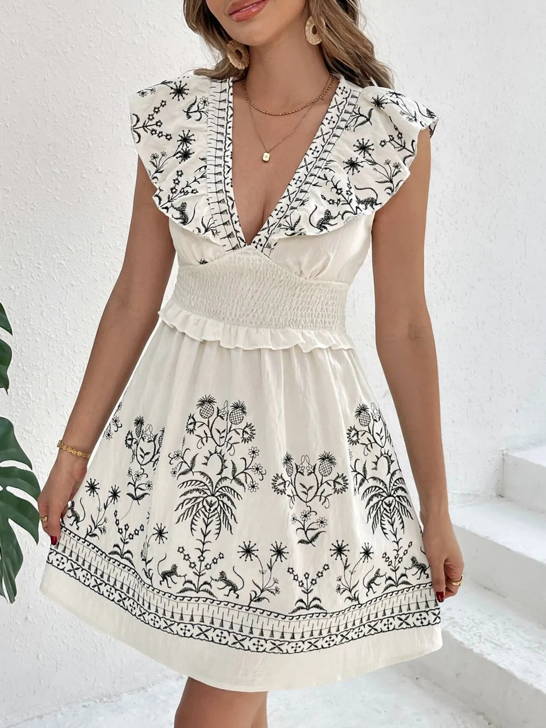 Cream Woodland Muse smocked mini dress by Trendsi, front view on model showcasing ruffled neckline and fitted waist.